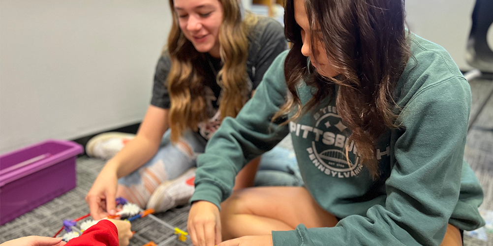 Two girls building with Knex