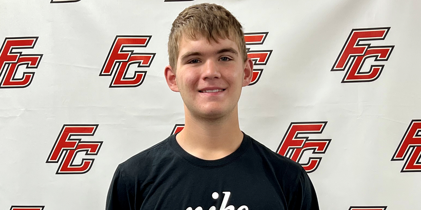 Picture of student in front of FC backdrop